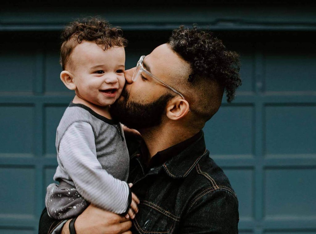 A young dad holding his child.